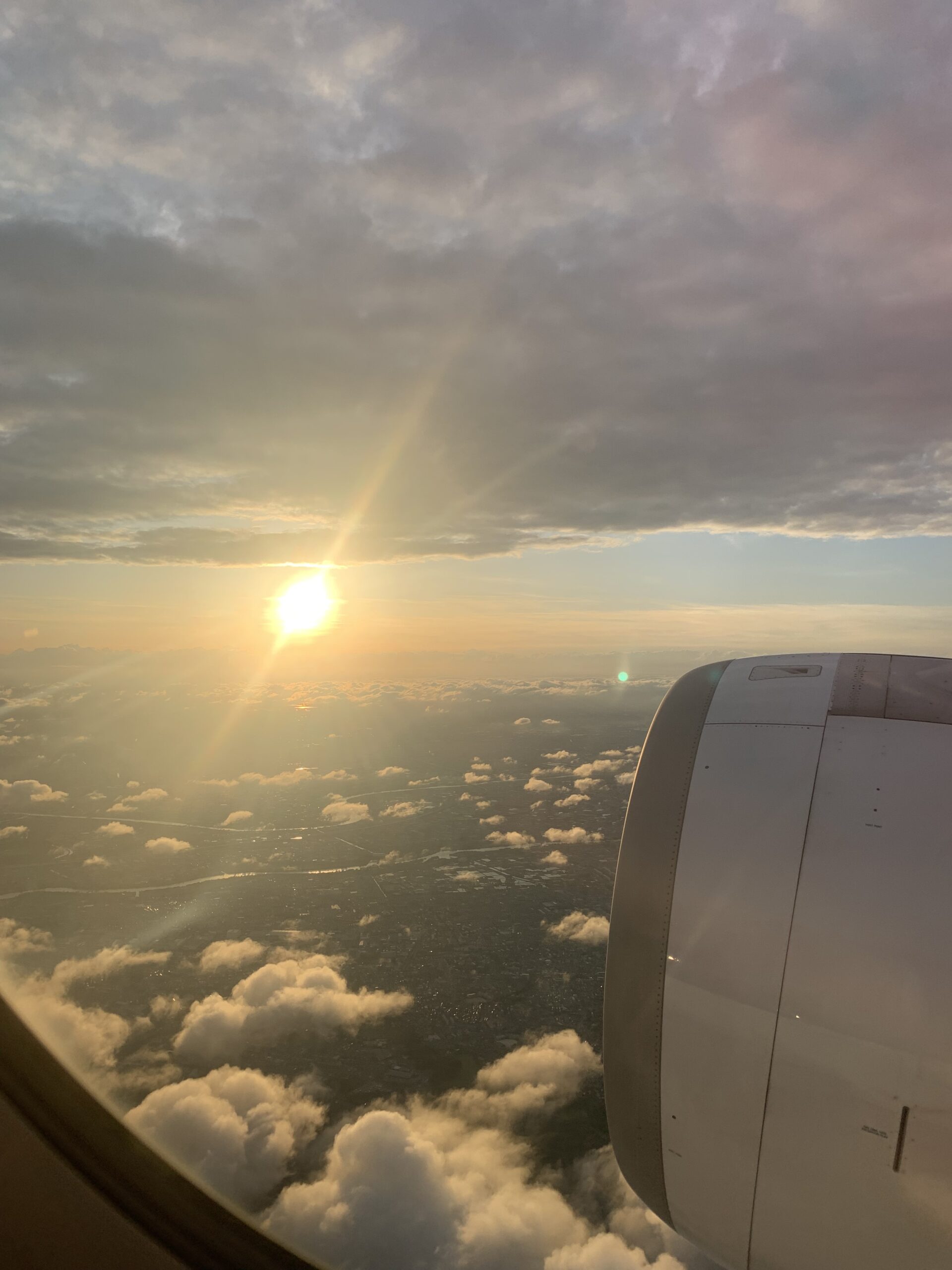 飛行機の窓から見える朝日と雲海